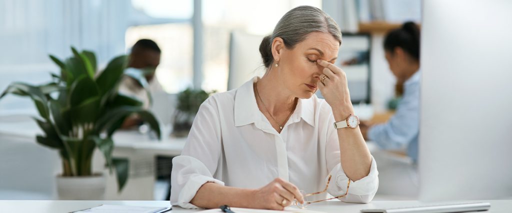 femme se prenant la tête avec une fatigue oculaire et insuffisance de convergence