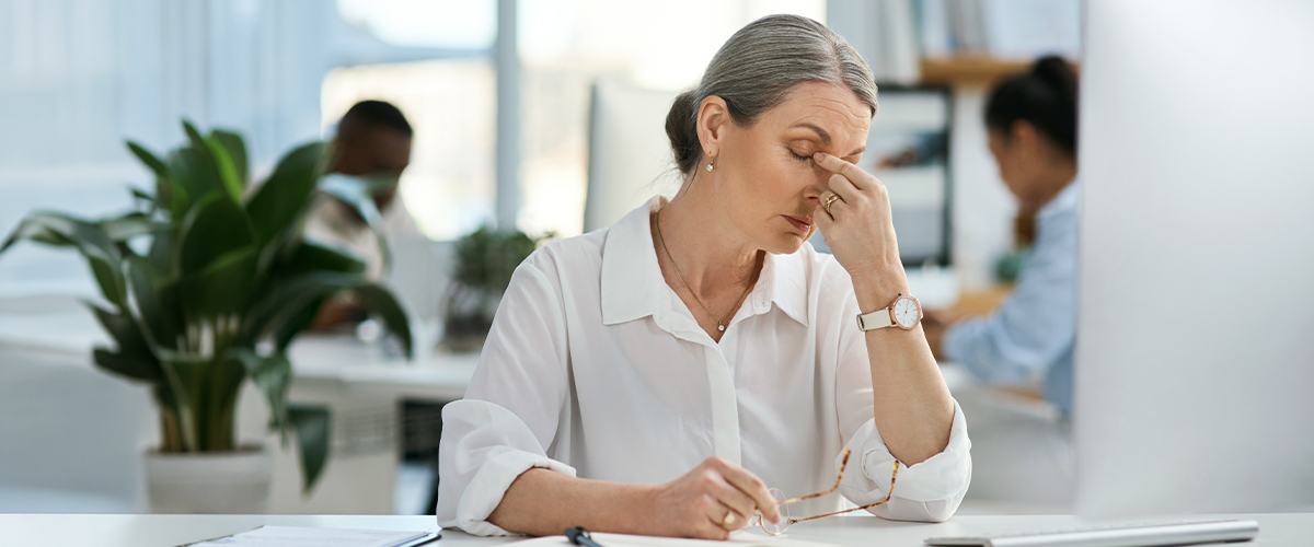 femme se prenant la tête avec une fatigue oculaire et insuffisance de convergence