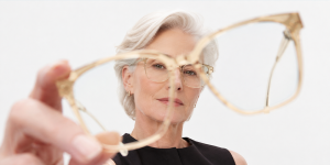 Femme tenant une monture de lunettes devant son visage